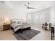 Bright main bedroom showcasing a tray ceiling, neutral walls, and plantation shutters on the windows at 1044 Alcove Loop, The Villages, FL 32162