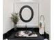 Stylish powder room with decorative sink, black countertop, and a round mirror at 1044 Alcove Loop, The Villages, FL 32162