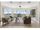 Bright sun room with a ceiling fan and sliding glass doors to the outdoor pool and golf course at 1044 Alcove Loop, The Villages, FL 32162