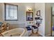 Well-lit bathroom showcasing a soaking tub, pedestal sink, and stylish accents at 10909 Mattioda Rd, Groveland, FL 34736