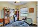 Bedroom with a cozy beanbag chair, built in shelving, and outside view from the large window at 10909 Mattioda Rd, Groveland, FL 34736