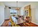 Charming dining room with rustic wood table, chandelier, and plenty of natural light at 10909 Mattioda Rd, Groveland, FL 34736