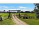 Welcoming property entrance featuring a gated driveway and scenic views of the home at 10909 Mattioda Rd, Groveland, FL 34736