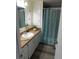 Bathroom showcases a sink with vanity, mirror, and bathtub with a shower curtain at 110 Oleander Cv, Leesburg, FL 34748