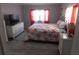 Cozy bedroom features a white dresser, wicker nightstand, and a floral-patterned bedspread at 110 Oleander Cv, Leesburg, FL 34748