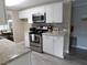 Bright kitchen featuring granite countertops, stainless steel appliances, and updated white cabinetry at 110 Oleander Cv, Leesburg, FL 34748