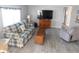 Comfortable living room featuring a large window, modern wood-look flooring, and ample seating, creating a cozy atmosphere at 110 Oleander Cv, Leesburg, FL 34748