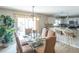 Open dining area with glass-top table, chandelier, and a view into the adjacent kitchen at 1137 Alfredo Ave, The Villages, FL 32159