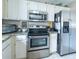 Modern kitchen featuring white cabinets, stainless steel appliances, and granite countertops at 1137 Alfredo Ave, The Villages, FL 32159