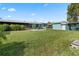 Expansive backyard features a lush lawn, screened porch, and additional storage shed at 11820 Watts Ct, Tavares, FL 32778