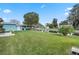 Wide backyard that goes to the channel, lush lawn, small palm tree, with a patio set off the back of the house at 11820 Watts Ct, Tavares, FL 32778