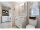 Bathroom with white vanity, mirror, and adjacent laundry area at 11820 Watts Ct, Tavares, FL 32778