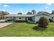 Charming single-story home with a well-manicured lawn and covered carport in a quiet neighborhood at 11820 Watts Ct, Tavares, FL 32778