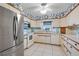 Well-lit kitchen featuring white cabinets, stainless steel appliances, and decorative blue trim at 11820 Watts Ct, Tavares, FL 32778