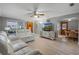 Open-concept living room featuring light wood floors and white sofas at 11820 Watts Ct, Tavares, FL 32778