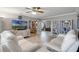 Spacious living room featuring a large TV, stylish decor, and neutral color palette at 11820 Watts Ct, Tavares, FL 32778