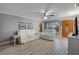 Bright living room with light wood floors, neutral walls, ceiling fan and furniture at 11820 Watts Ct, Tavares, FL 32778