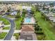 Aerial view of a community pool, tennis courts, and a pond with lush landscaping and well-maintained grounds at 12335 Se 176Th Loop, Summerfield, FL 34491