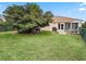 A cozy patio area with outdoor seating overlooks the expansive, well-manicured backyard at 12335 Se 176Th Loop, Summerfield, FL 34491