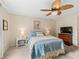 Cozy bedroom features a leaf-blade ceiling fan, soft carpet, and comfortable furnishings at 12335 Se 176Th Loop, Summerfield, FL 34491