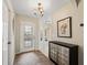 Bright foyer featuring tile floors, decorative rug, cabinet, and glass front door at 12335 Se 176Th Loop, Summerfield, FL 34491