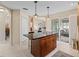 Bright kitchen view of the island, a doorway, and sliding glass doors leading to the enclosed lanai at 12335 Se 176Th Loop, Summerfield, FL 34491