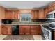 Kitchen featuring stainless steel appliances, wooden cabinets, and granite countertops at 12335 Se 176Th Loop, Summerfield, FL 34491