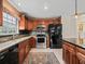 Well-lit kitchen features wood cabinetry, stainless steel appliances, granite countertops, and black backsplash at 12335 Se 176Th Loop, Summerfield, FL 34491