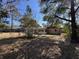 Back of home showing backyard, enclosed sunroom, and surrounding trees at 13 Spring Loop, Ocala, FL 34472