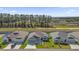 A lovely aerial view of three homes that showcases the landscaping, driveways, and proximity to natural surroundings at 1392 Kenneth St, The Villages, FL 34762