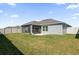 View of backyard showing the home's screened in patio at 1392 Kenneth St, The Villages, FL 34762