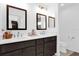 Bathroom with double sink vanity with dark cabinets, large mirrors, and modern fixtures at 1392 Kenneth St, The Villages, FL 34762