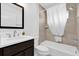 Well-lit bathroom featuring a vanity with dark wood cabinets, a toilet, and a shower-tub combination at 1392 Kenneth St, The Villages, FL 34762