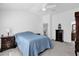 Bright bedroom features a ceiling fan, light gray carpet, and an ensuite bathroom at 1392 Kenneth St, The Villages, FL 34762