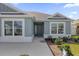 Inviting front entrance showcasing a gray front door, tidy landscaping, and a well-lit walkway at 1392 Kenneth St, The Villages, FL 34762