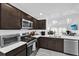 Modern kitchen featuring stainless steel appliances, white countertops, and dark wood cabinetry at 1392 Kenneth St, The Villages, FL 34762