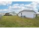 Backyard featuring a well-maintained lawn, the side of the house, and a fence at 1430 Mohawk Cir, Tavares, FL 32778