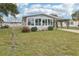 Inviting home featuring enclosed porch area with many windows, carport, lawn and concrete drive at 1430 Mohawk Cir, Tavares, FL 32778