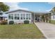 Charming home with enclosed porch boasting lots of windows, a covered carport, and verdant lawn at 1430 Mohawk Cir, Tavares, FL 32778