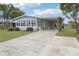 Charming home features an enclosed porch with lots of windows, carport, landscaping and a concrete drive at 1430 Mohawk Cir, Tavares, FL 32778