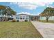 Charming single-story home with a spacious lawn, enclosed sunroom, and convenient carport at 1430 Mohawk Cir, Tavares, FL 32778