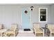 Inviting home with cozy front porch seating area and bright blue door at 1430 Mohawk Cir, Tavares, FL 32778