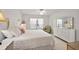 Bright bedroom with a large bed, dresser with mirror, and natural light at 1508 Dellano Way, The Villages, FL 32159