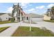 Charming home with a well-manicured lawn, palm trees, white exterior, and ample driveway space at 1508 Dellano Way, The Villages, FL 32159