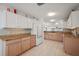 Bright kitchen featuring white cabinets, light countertops, and tile flooring at 1508 Dellano Way, The Villages, FL 32159