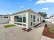 Exterior view of a home with a sunroom, white walls, and a well-maintained walkway at 1558 Summerchase Loop, The Villages, FL 32162