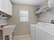 Bright laundry room with white washer and dryer, utility sink, window and shelving at 1558 Summerchase Loop, The Villages, FL 32162