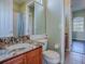 Bathroom featuring granite countertop vanity, toilet, tile floors and open doorway to bedroom at 16126 Bristol Lake Cir, Orlando, FL 32828