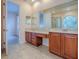 Bright bathroom features a dual sink vanity with wood cabinets and a decorative glass block window at 16126 Bristol Lake Cir, Orlando, FL 32828