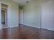 Bedroom with hardwood floors, light green walls, white doors, and two entryways at 16126 Bristol Lake Cir, Orlando, FL 32828